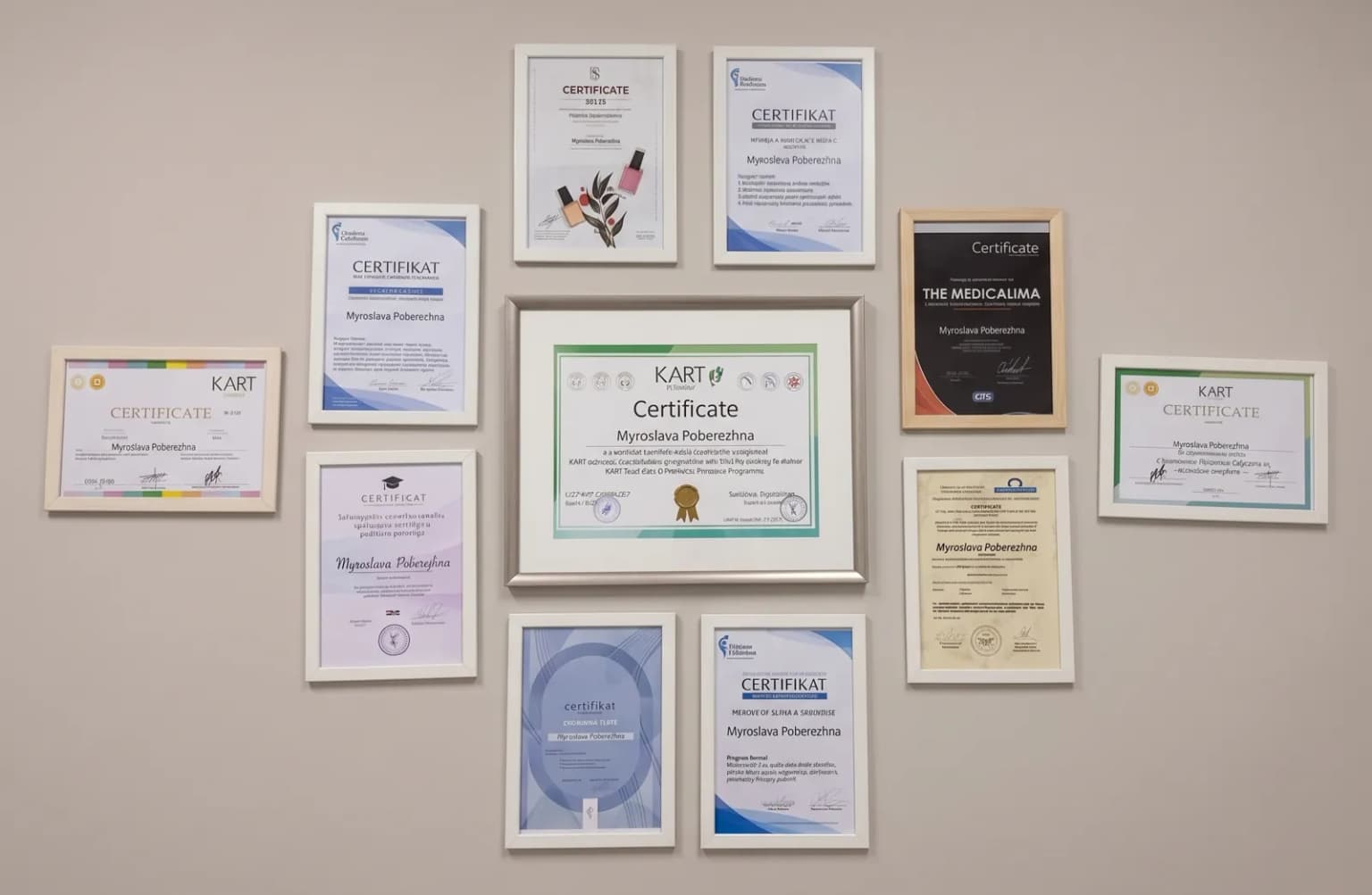 Zarámované certifikáty Myroslavy Poberezhne na stěně studia